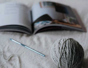 patron, balle de laine et aiguille sur une couverture